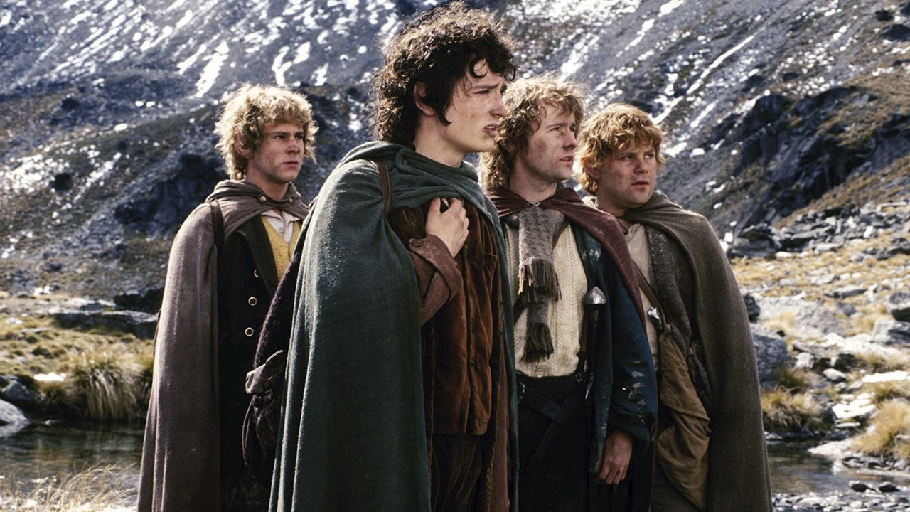 Quatro hobbits olhando para longe em O Senhor dos Anéis: A Sociedade do Anel.