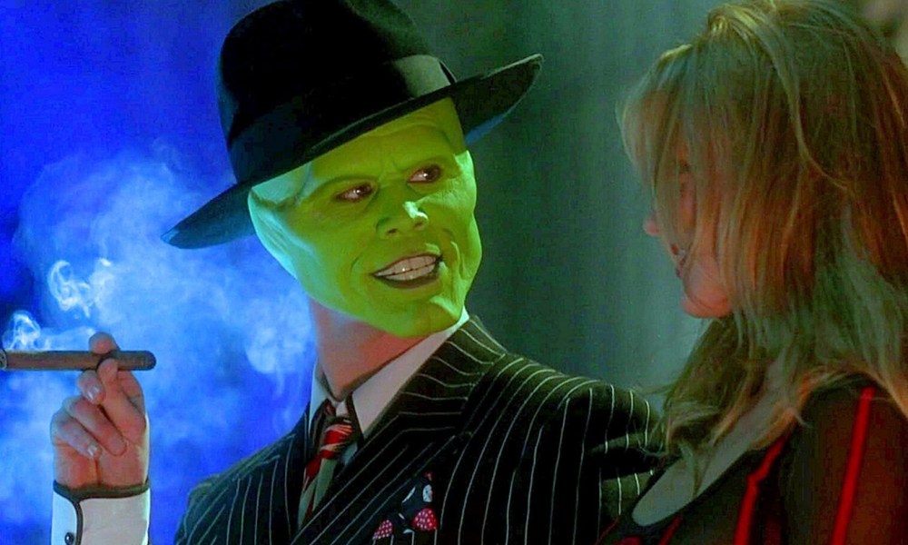 Jim Carrey with a green mask smoking a cigar and looking at a woman in The Mask.