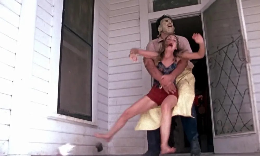 Leatherface grabs a girl in The Texas Chain Saw Massacre.