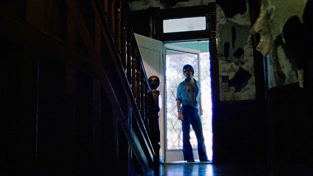 Kirk stands in a house doorway in The Texas Chain Saw Massacre.