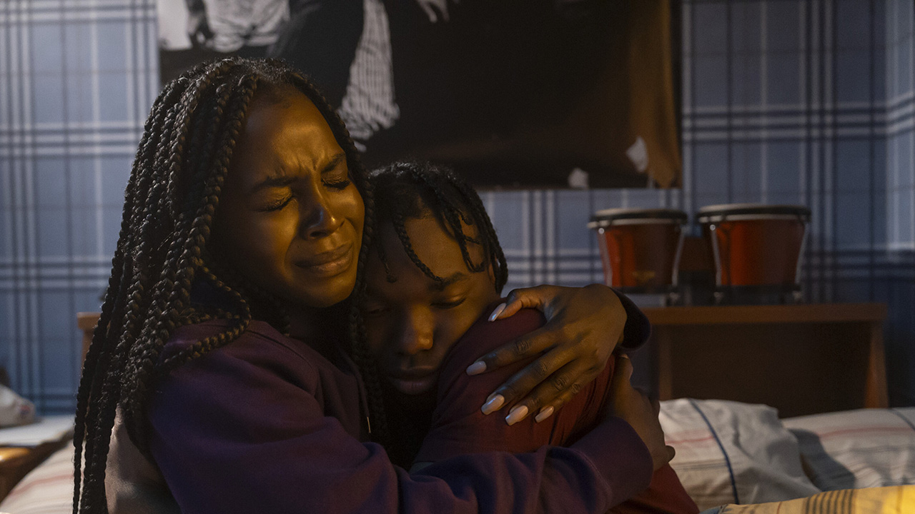 A woman hugs a child tight, both looking terrified in Them: The Scare.