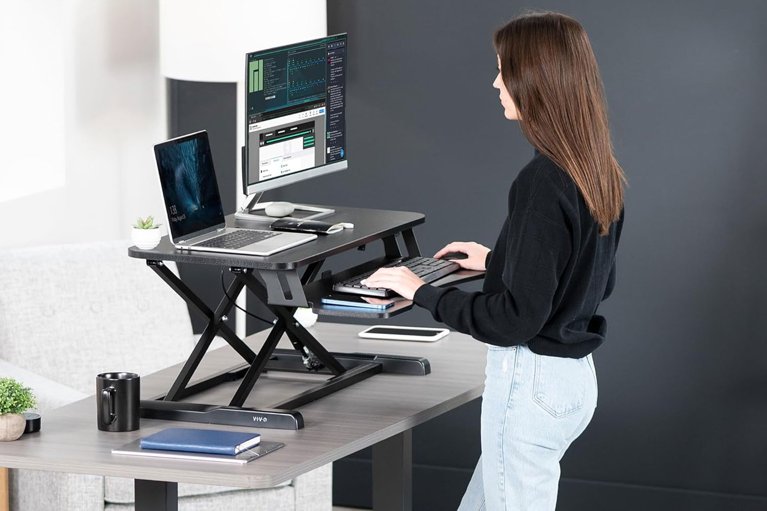 Woman standing at a Vivo desk converter.