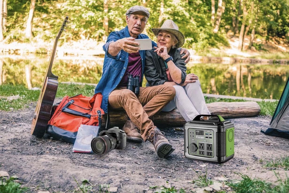 A camping couple using the iFanze 300W Portable Power Station.