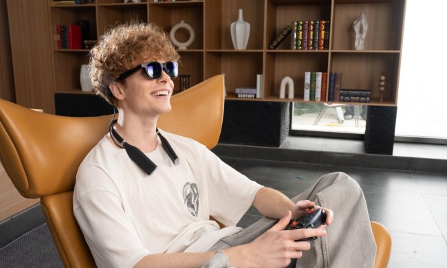 A person enjoys gaming with Viture Pro smart glasses and Pro Neckband.