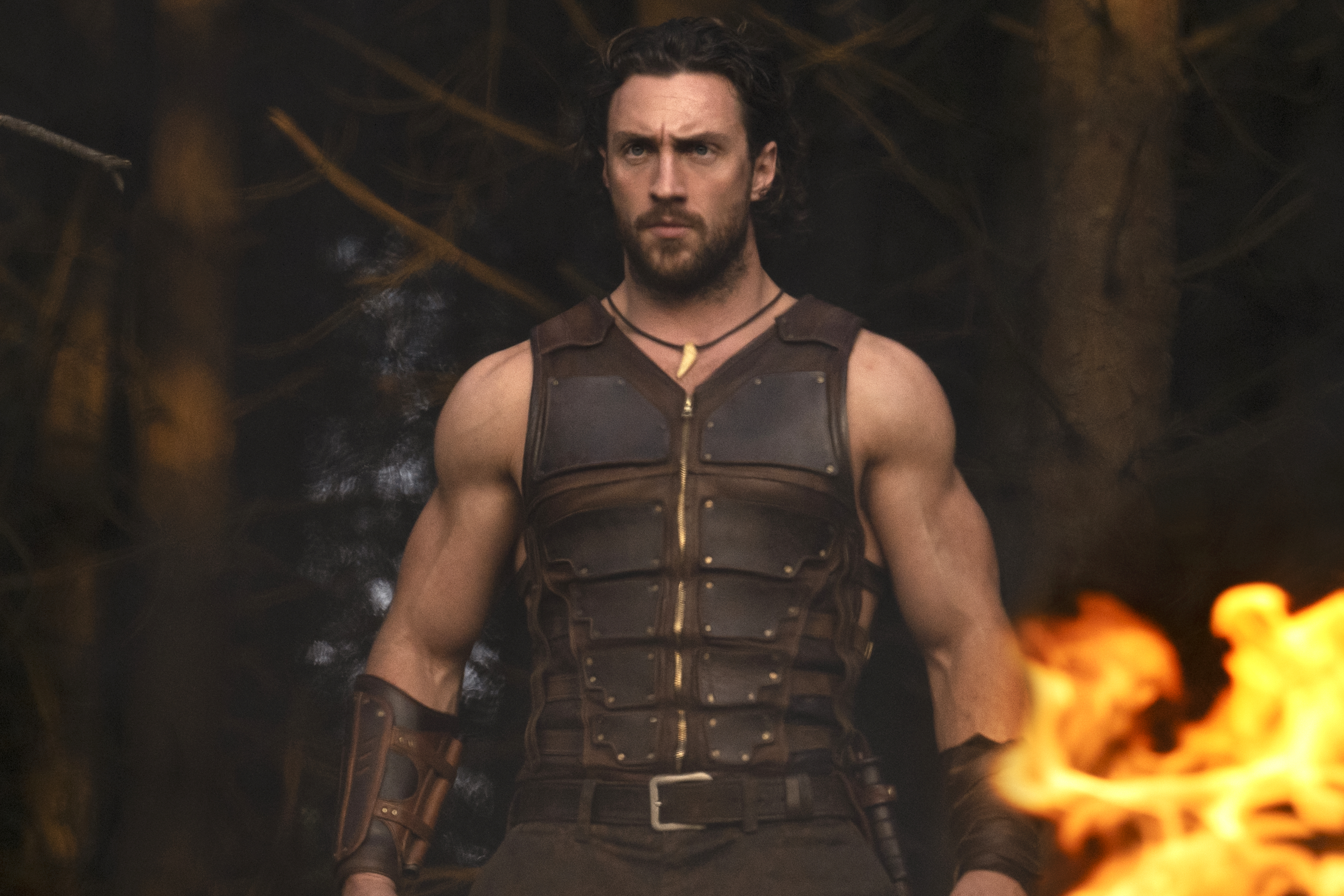 Aaron Taylor-Johnson se tient près du feu dans Kraven le chasseur.