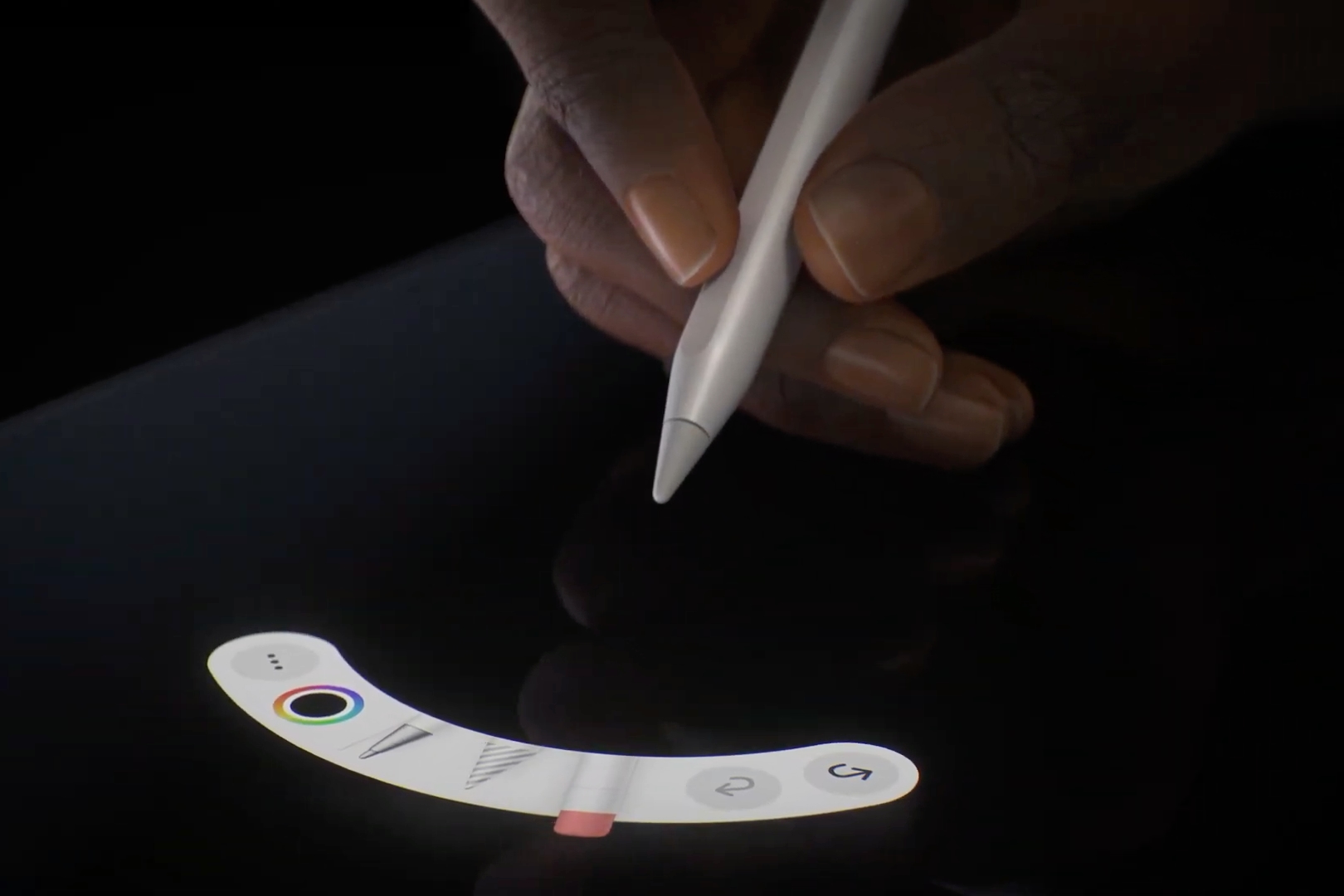 Mão segurando o Apple Pencil Pro mostrando a paleta de ferramentas do gesto de apertar.