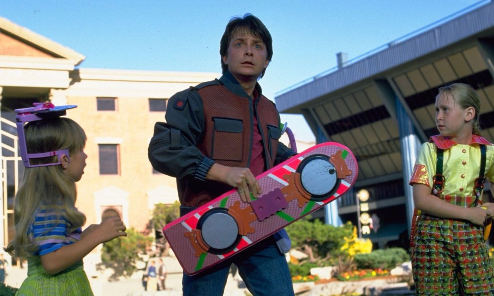 Marty McFly holds a hoverboard and stares.