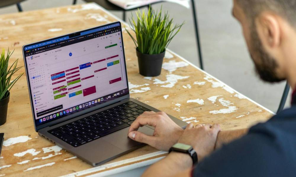 A man using Google Calendar on a laptop.