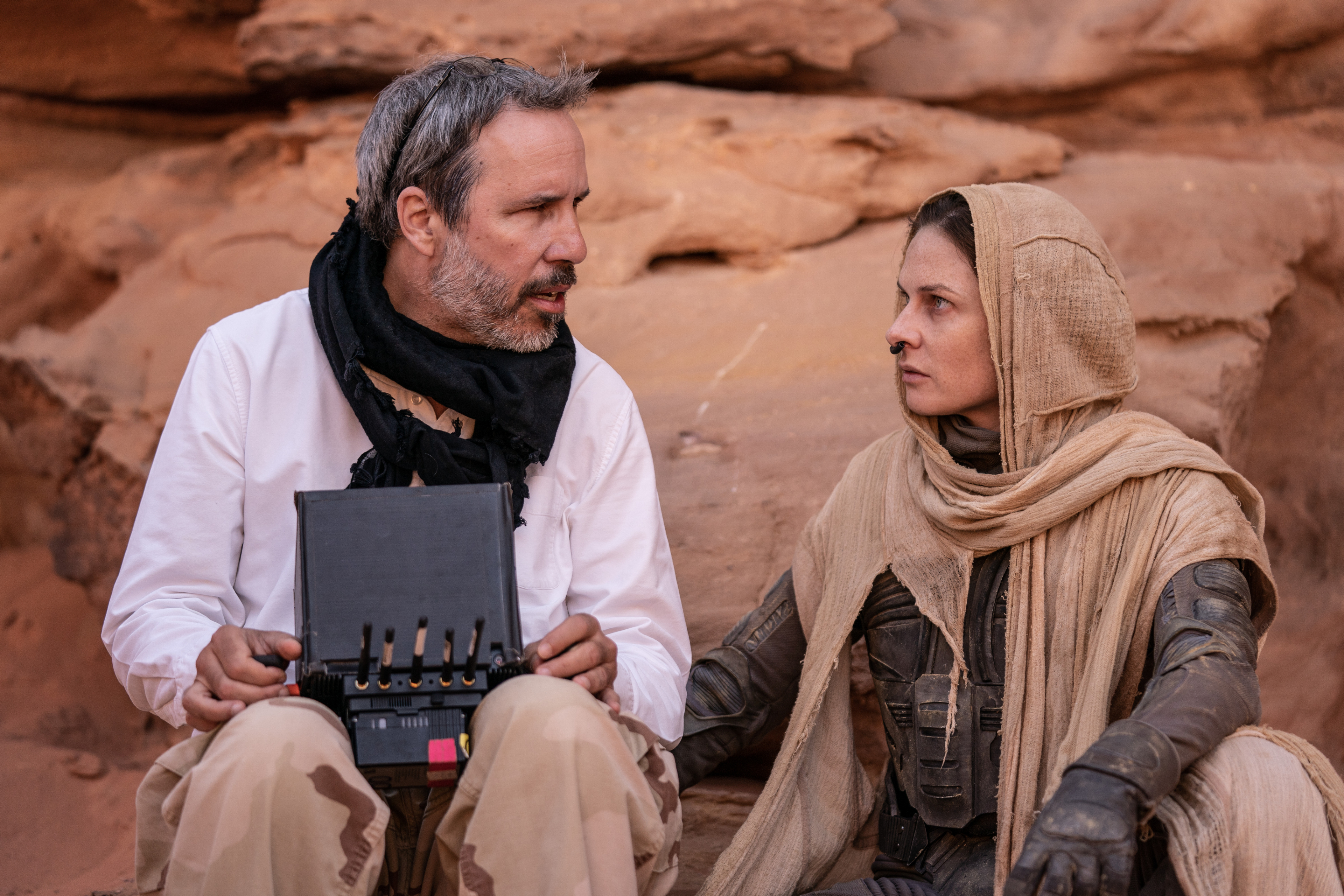 Denis Villeneuve sentado com Rebecca Ferguson no set de “Duna: Parte Dois”.