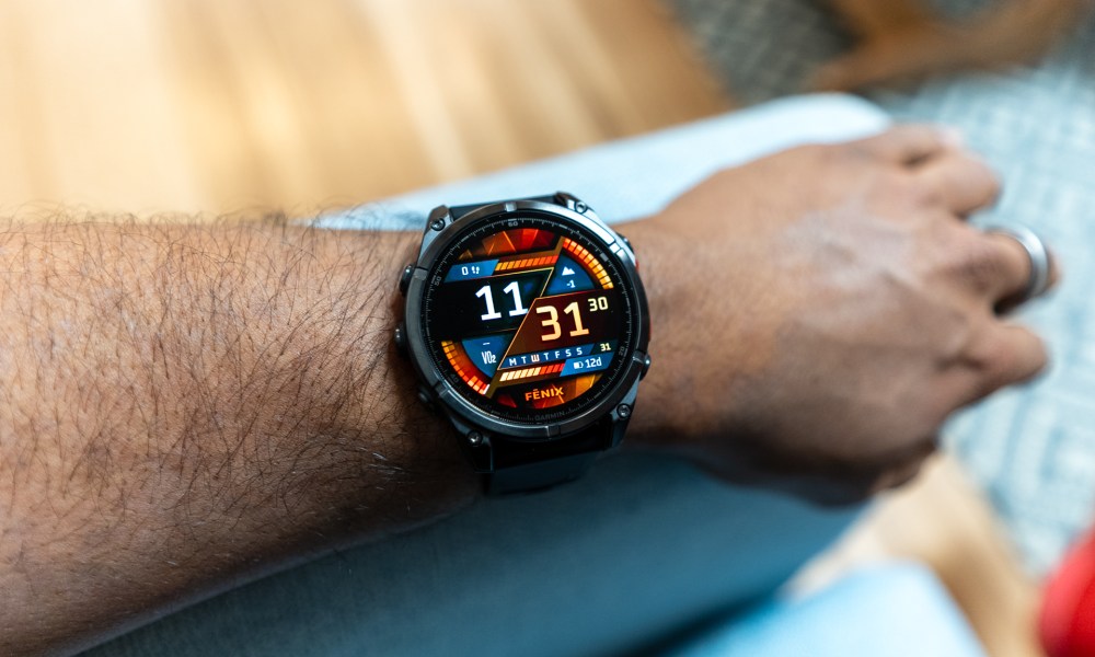 Garmin Fenix 8 on a wrist resting on a couch armrest