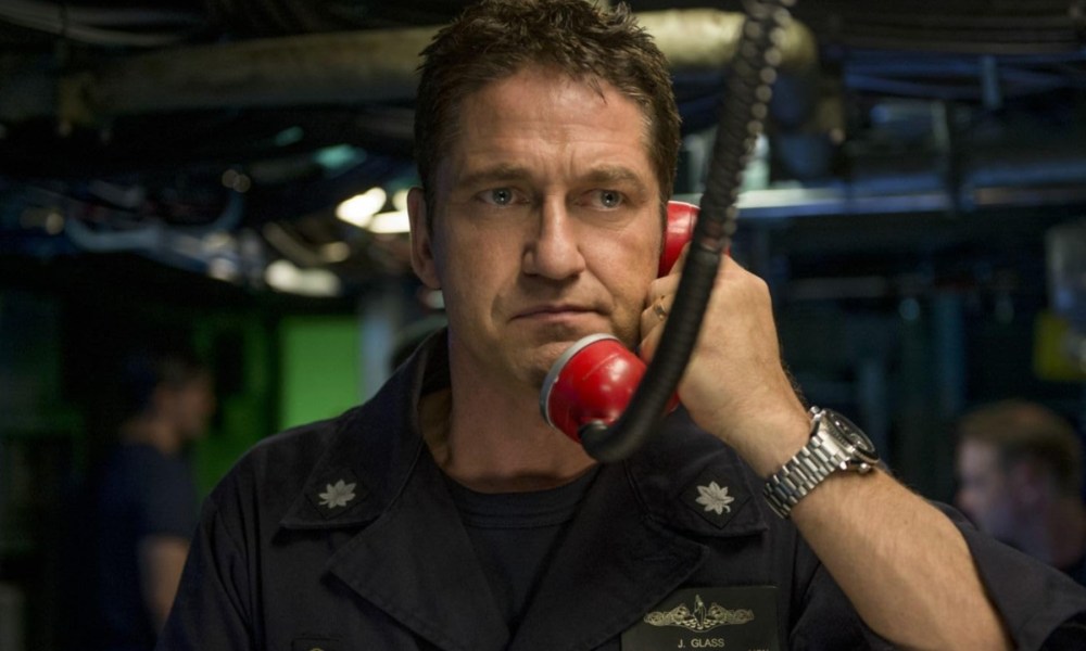 Gerard Butler holds a phone up to his ear.