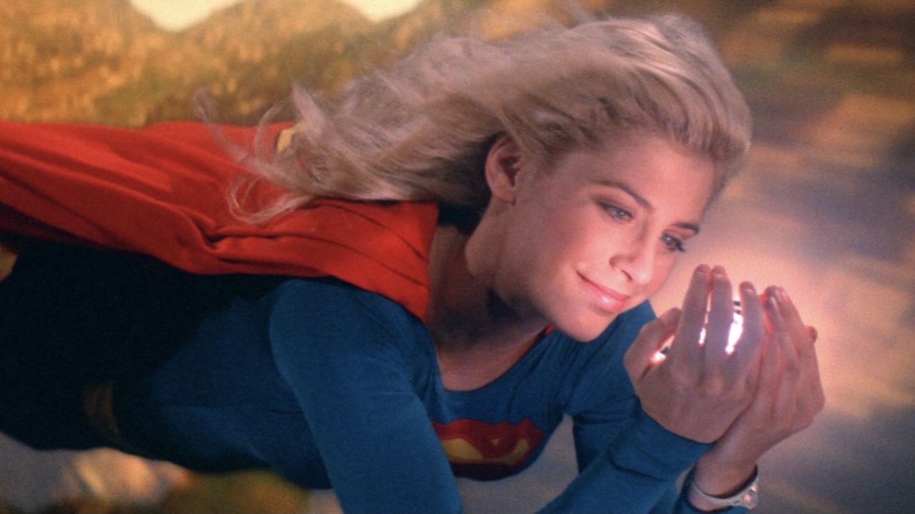 Helen Slater as Supergirl smiling while holding a glowing ball.