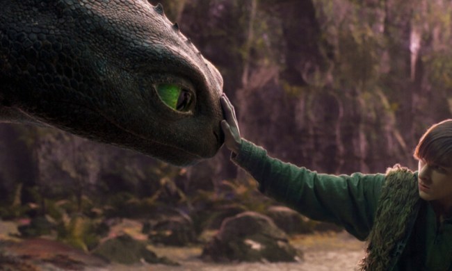 A boy touches the nose of a dragon.