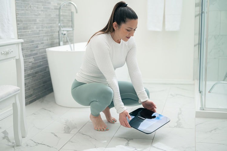 A person holding the Wyze Scale X.