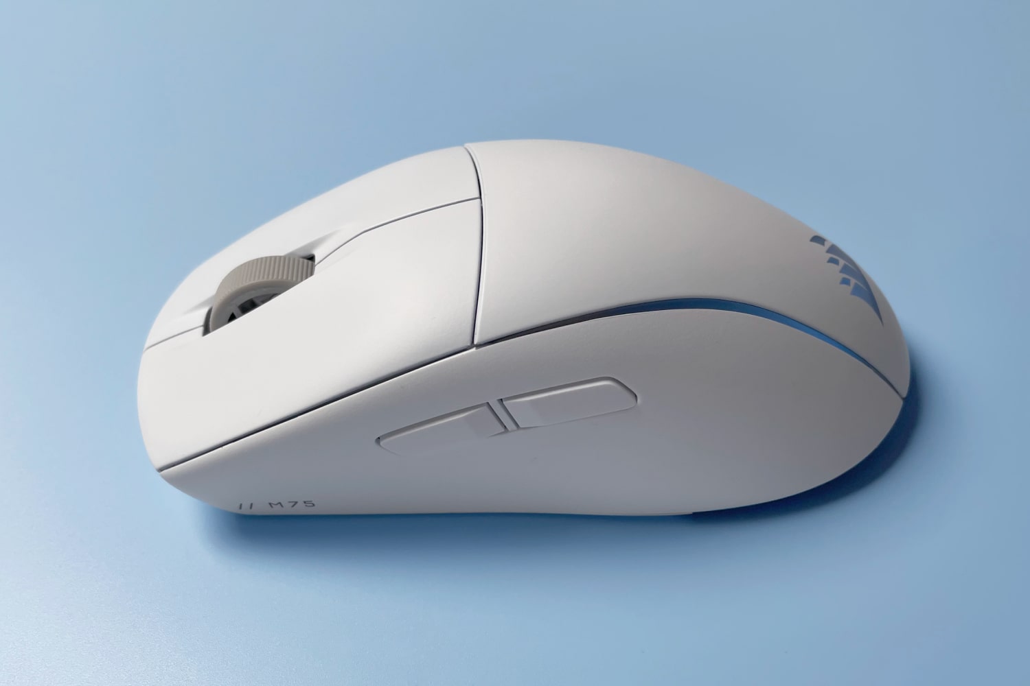 La souris Corsair M75 pour Mac sur fond bleu.