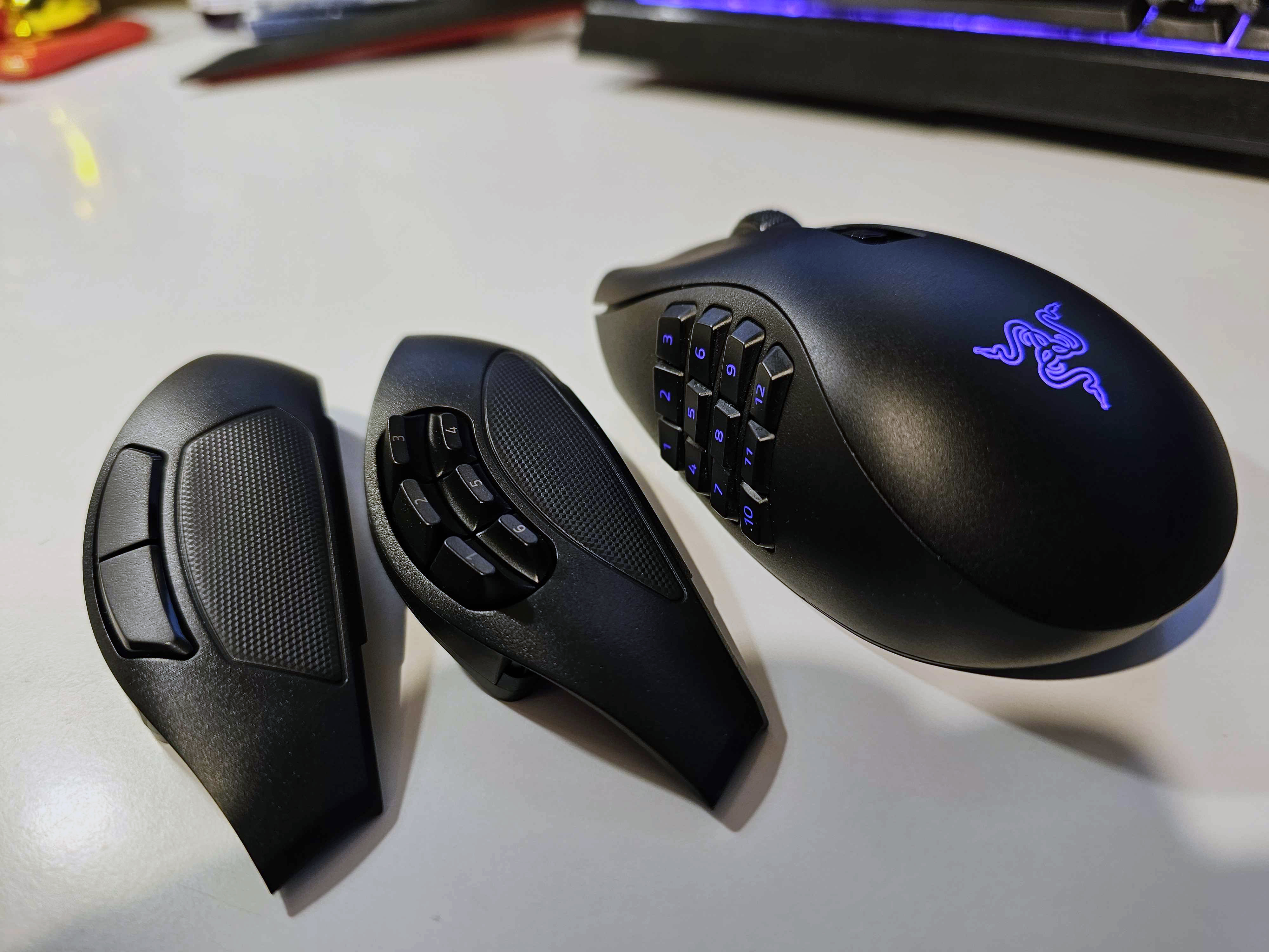 Игровая мышь Razer Naga V2 Pro на белом фоне с двумя сменными боковыми панелями.