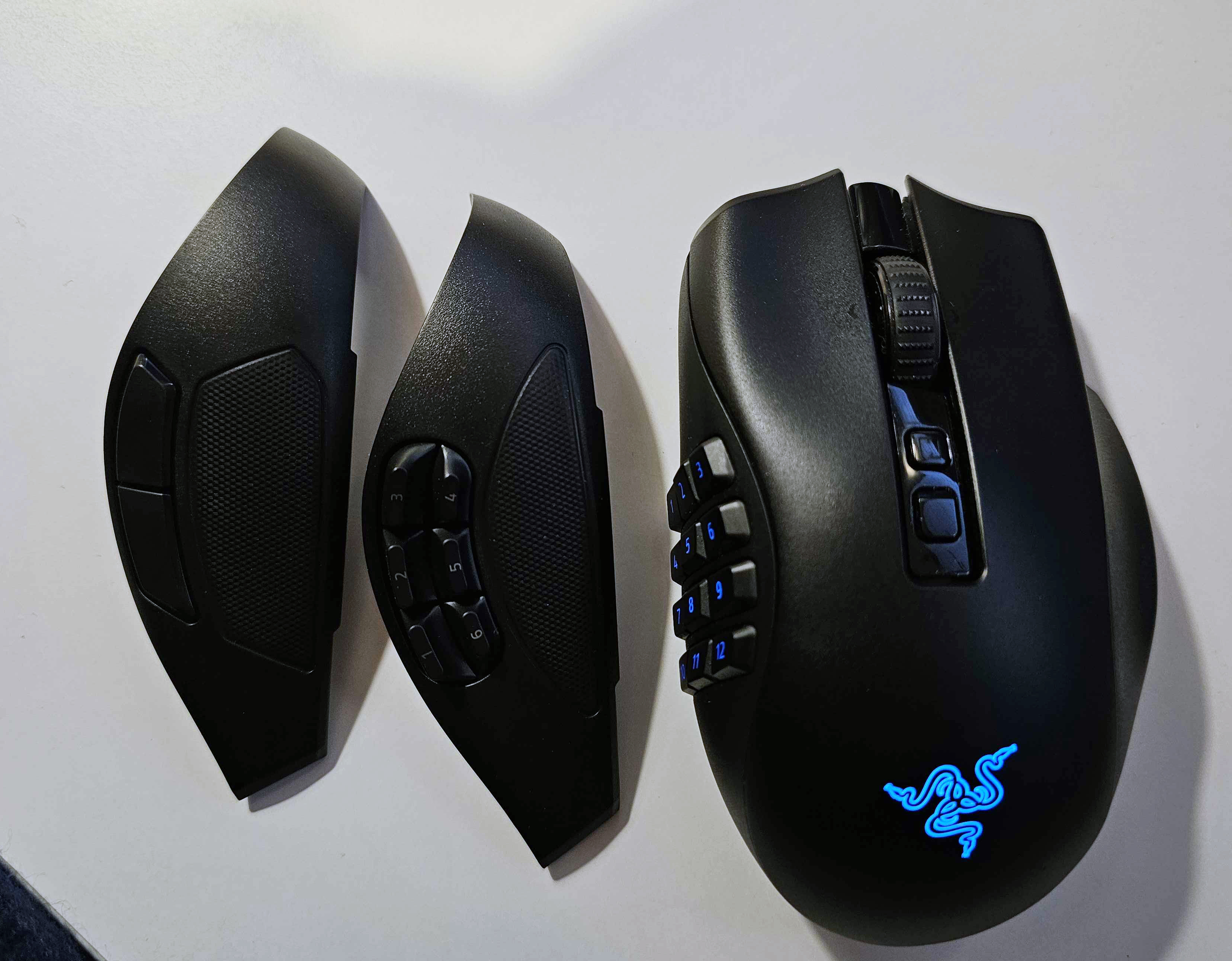 Игровая мышь Razer Naga V2 Pro на белом фоне с двумя сменными боковыми панелями.