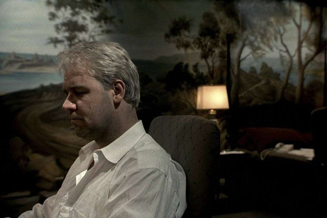 Russell Crowe sits in a hotel room in The Insider.