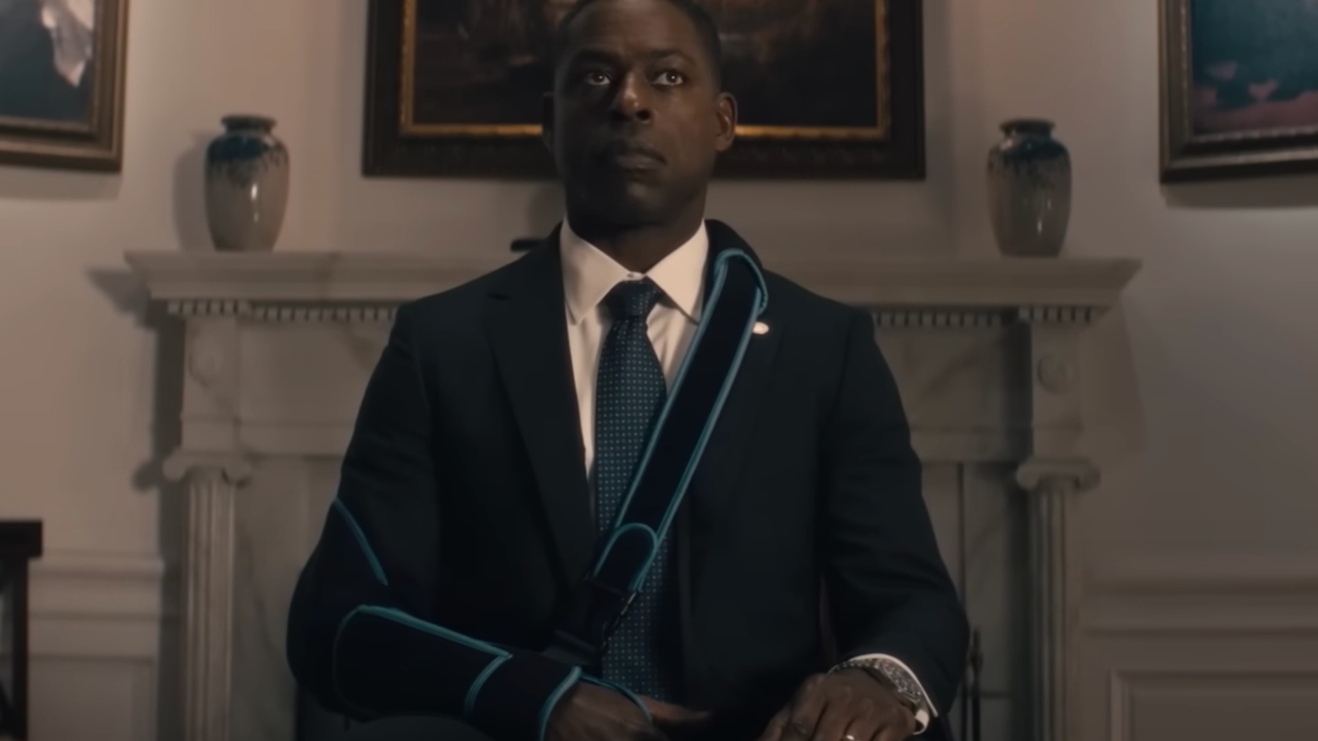 Sterling K. Brown est assis sur une chaise et porte une écharpe.