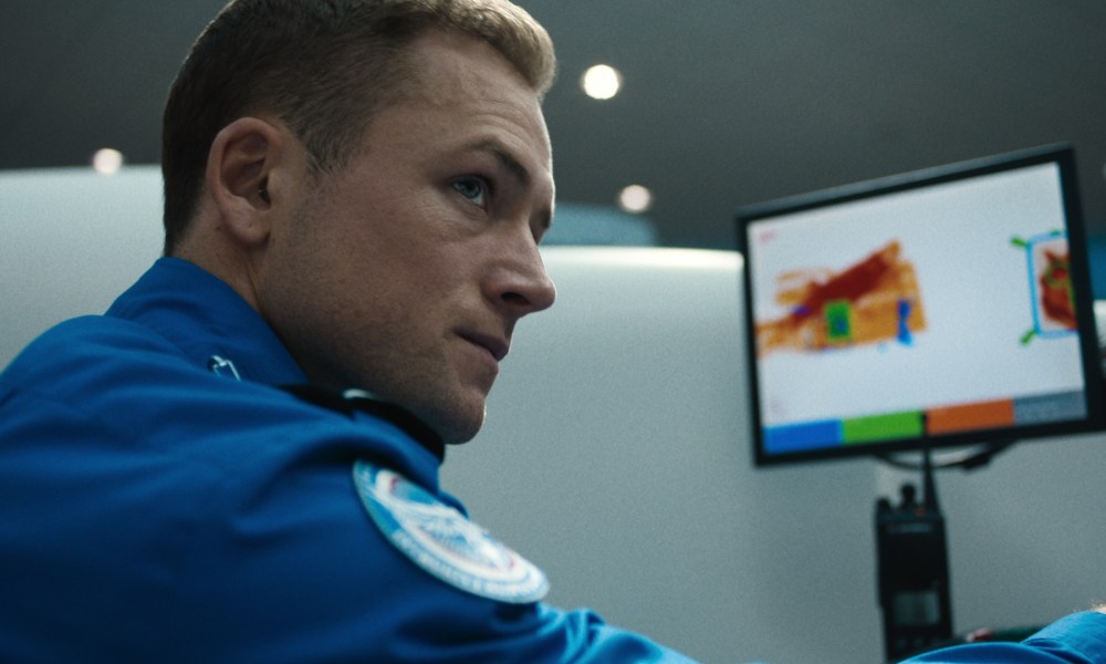 A TSA Agent looks to the right of his computer.