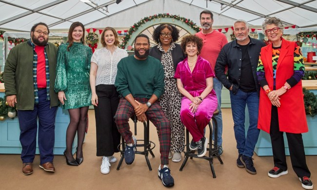 A group of celebrities and culinary professionals stand and sit.