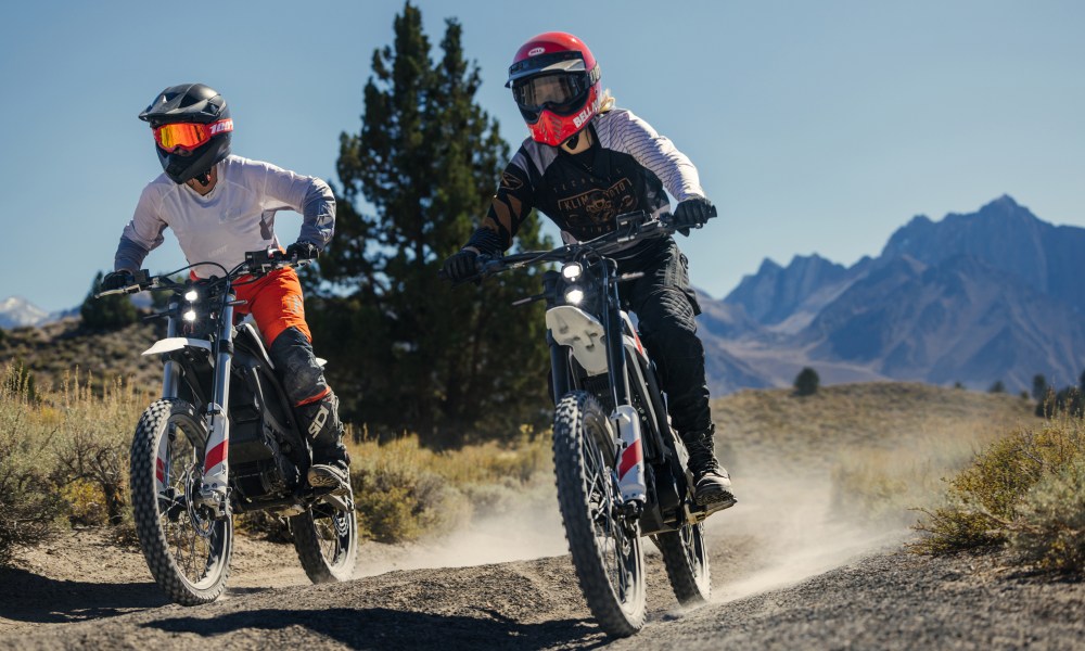 ZeroXB and ZeroXE riding on a dirt road in the desert, right front three-quarter view.