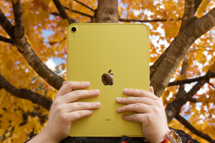 Duas mãos segurando um iPad.