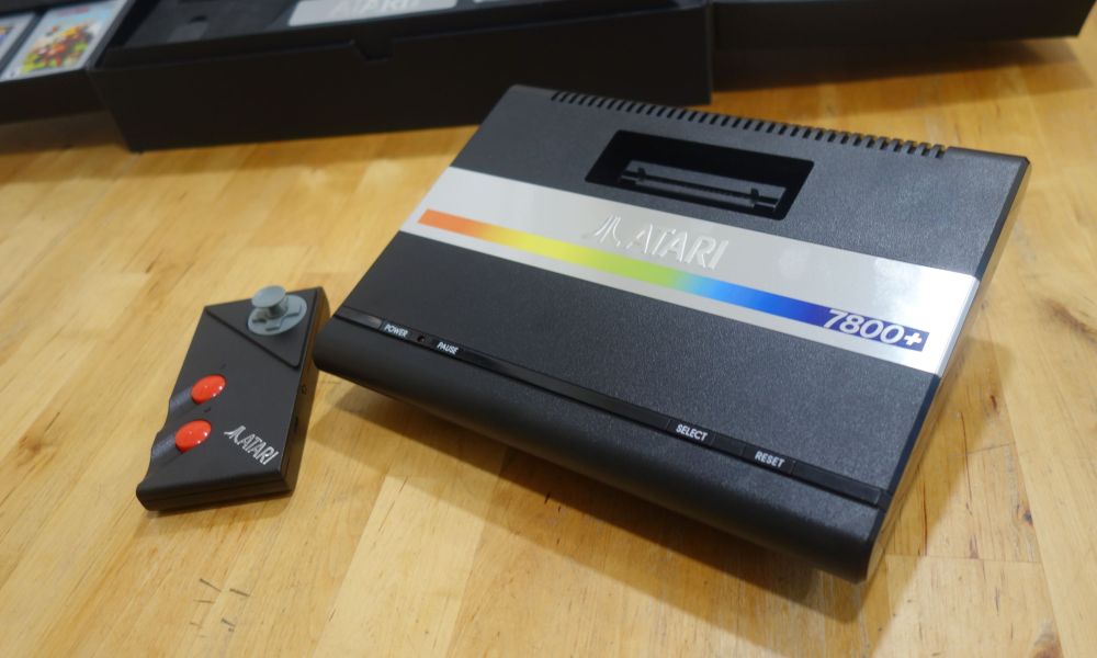 An Atari 7800+ sits on a table next to a controller.