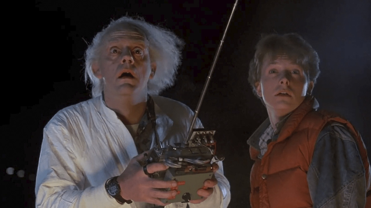 Doc using a machine with Marty beside him, both looking up stunned in Back to the Future.