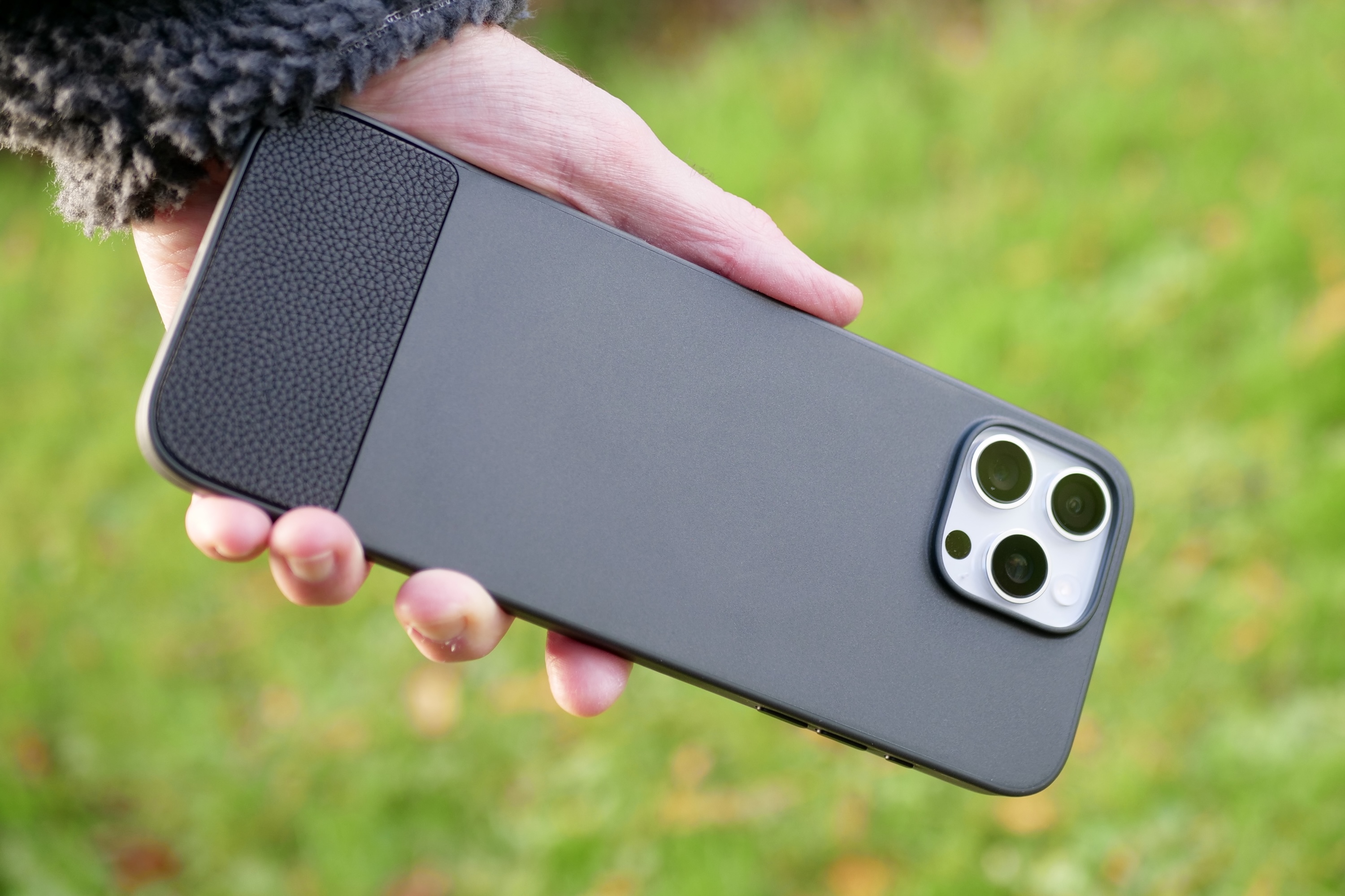 A person holding an iPhone 16 Pro Max inside the Clicks Keyboard case.