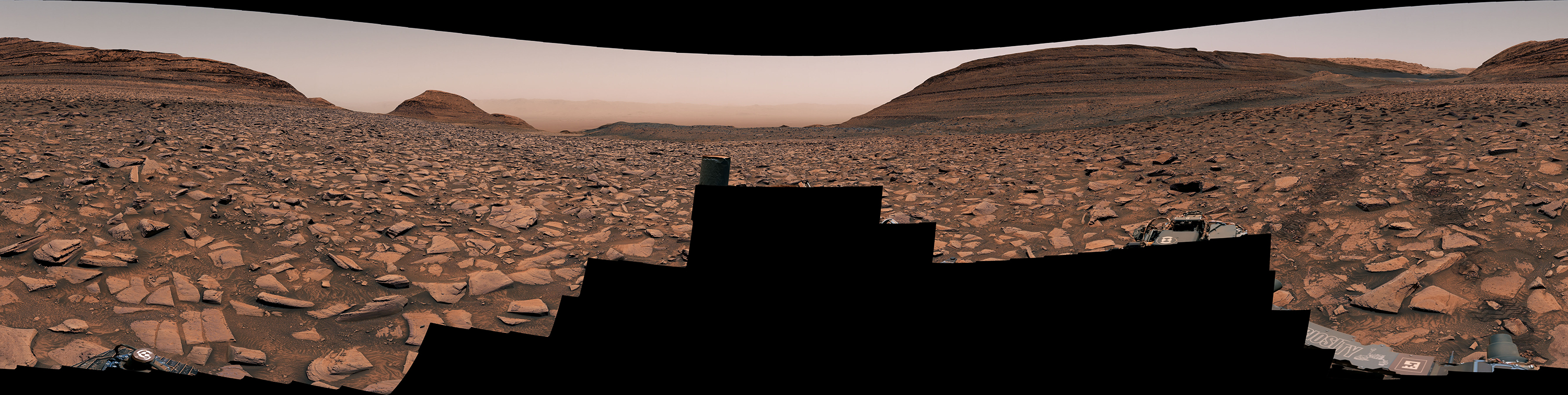 Curiosity der NASA hat dieses Panorama mit seiner Mastcam aufgenommen, als es am 2. November 2024, dem 4.352. Marstag oder Sol der Mission, nach Westen weg vom Gediz-Vallis-Kanal unterwegs war. Rechts sind die Spuren des Mars-Rover über das felsige Gelände zu sehen.