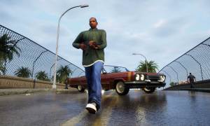 Carl Johnson in a green shirt walking away from a car on a bridge. He's holding a gun.