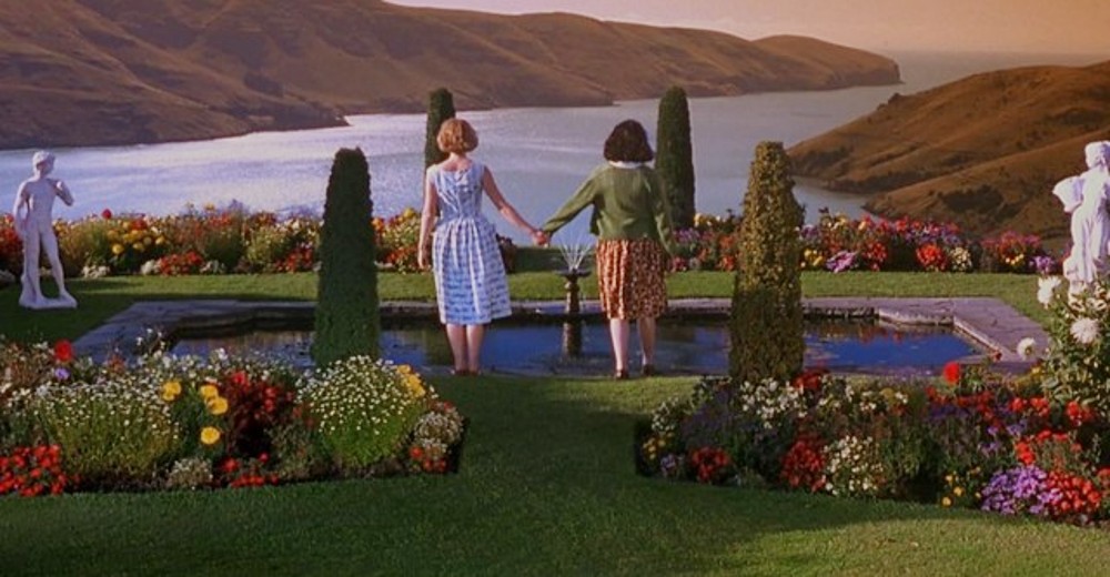 Two girls hold hands in Heavenly Creatures.