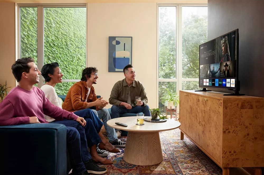 Un grupo de personas sentadas en un sofá viendo un televisor Xumo.