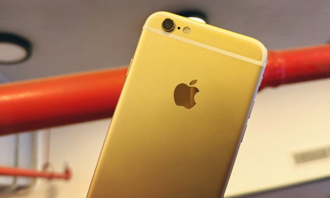 An iPhone 6S in gold held against a red pipe.