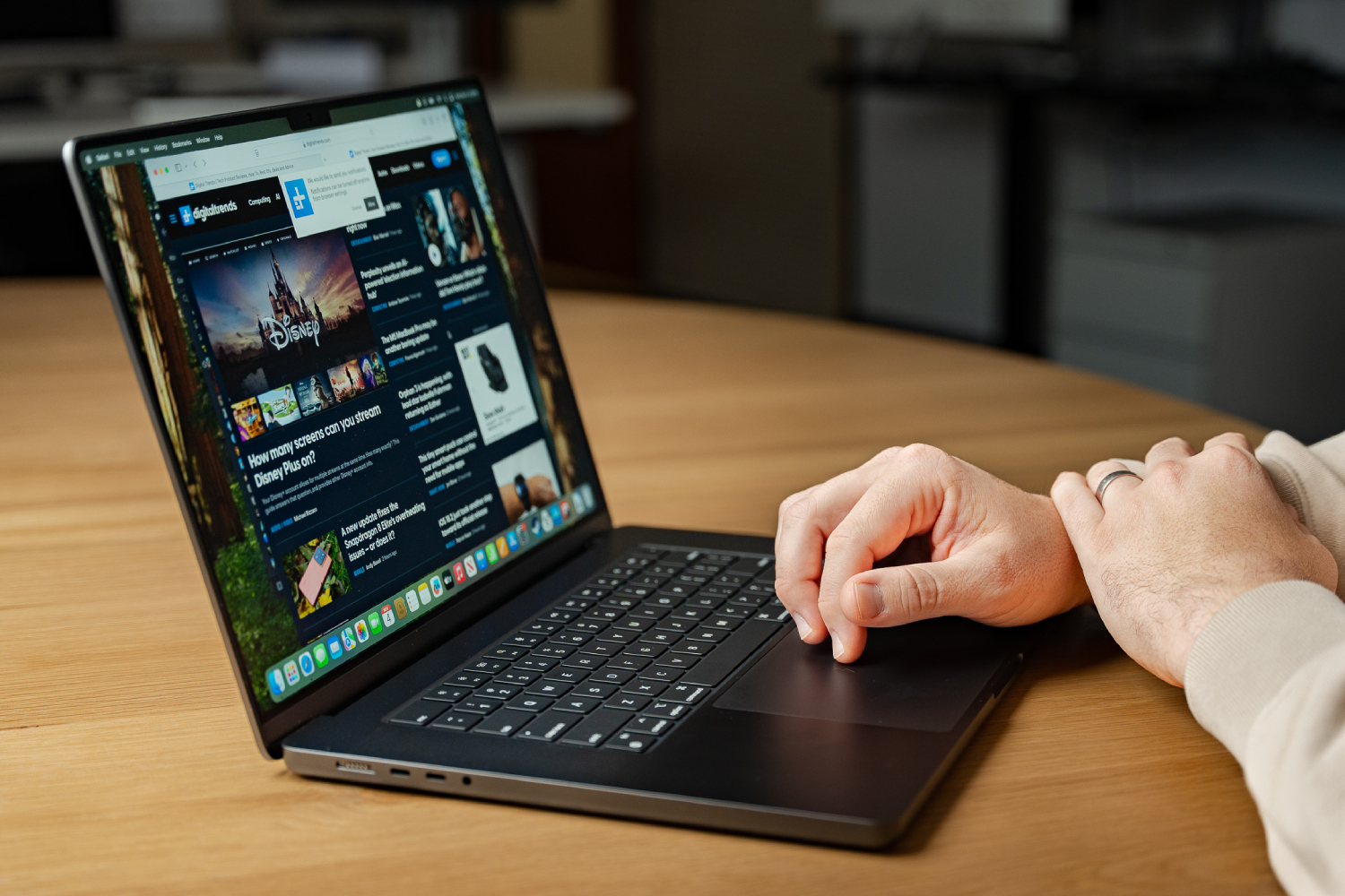 Alguém usando um MacBook Pro em uma mesa.