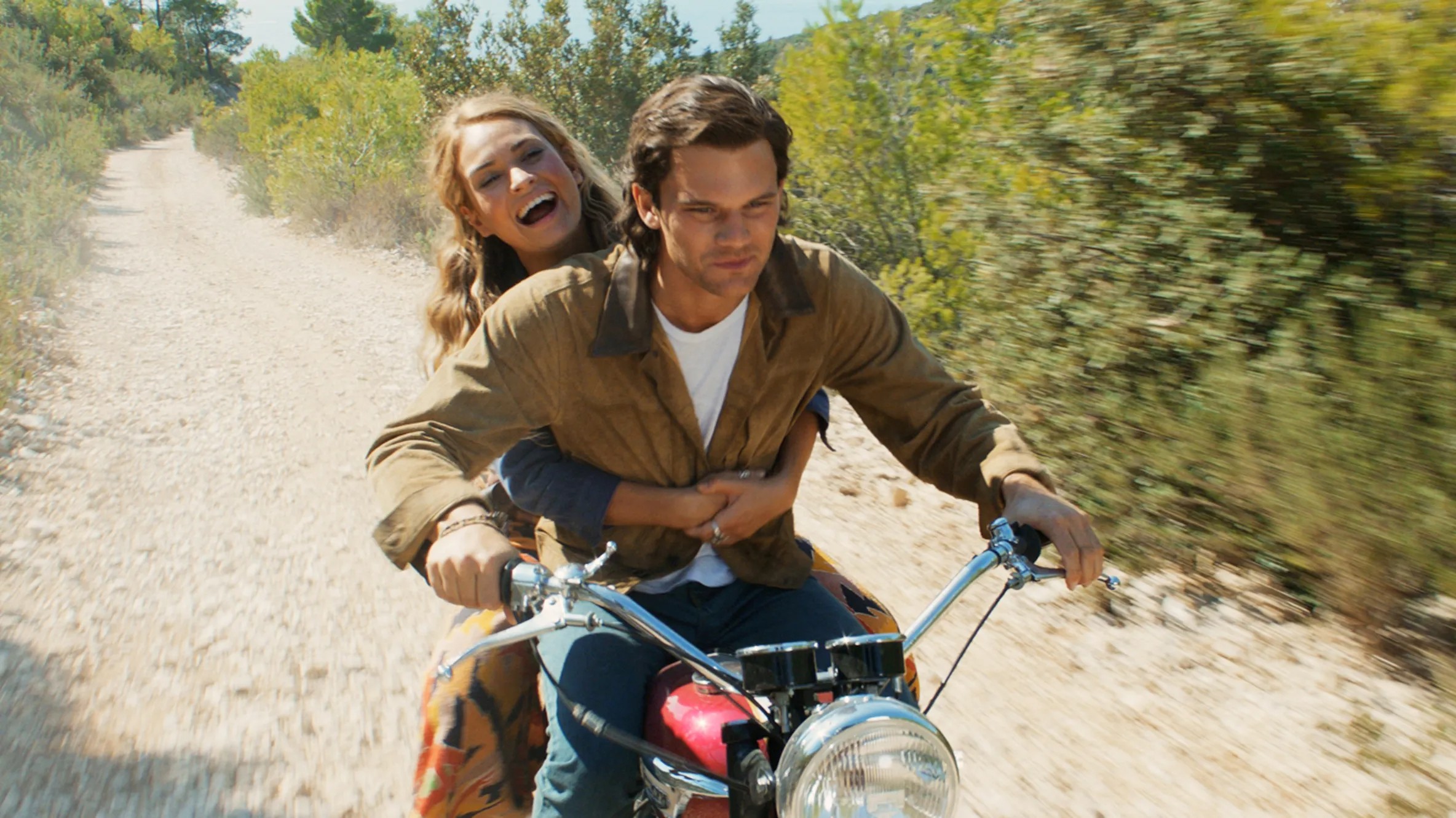 A man and a woman ride a motorcycle in Mamma Mia: Here We Go Again.