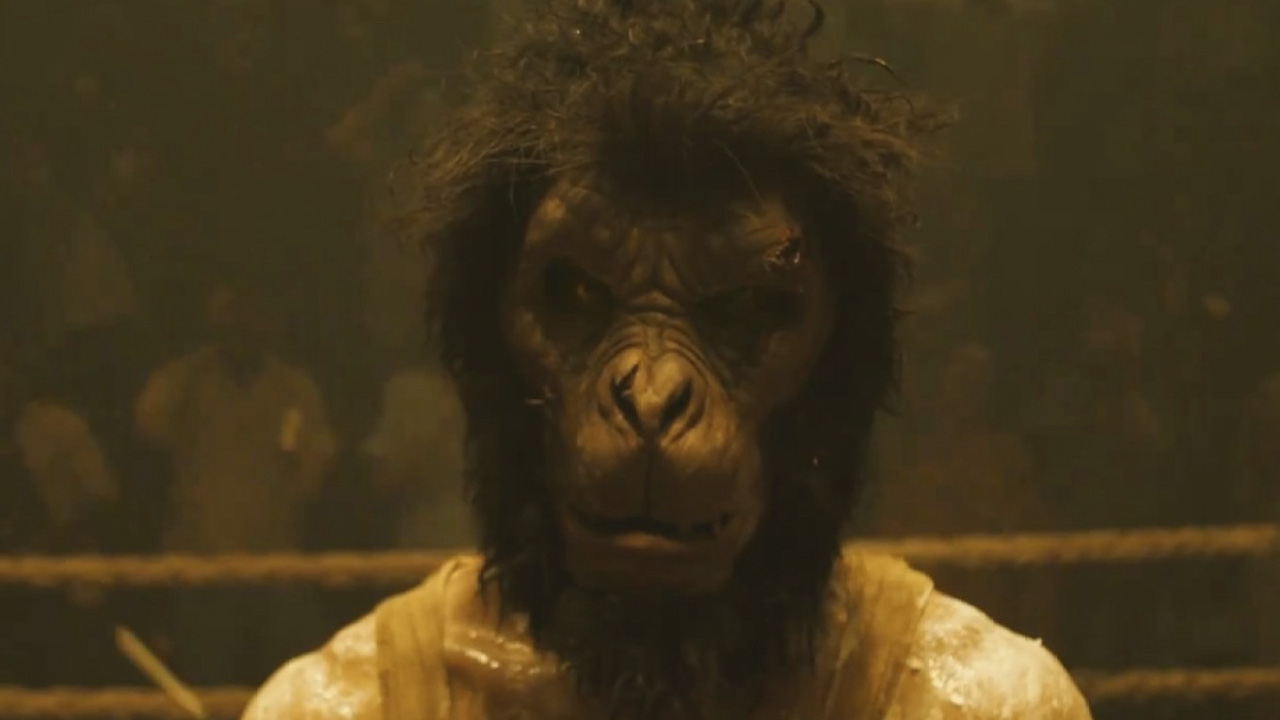 A man wearing a monkey mask in a scene from Monkey Man.