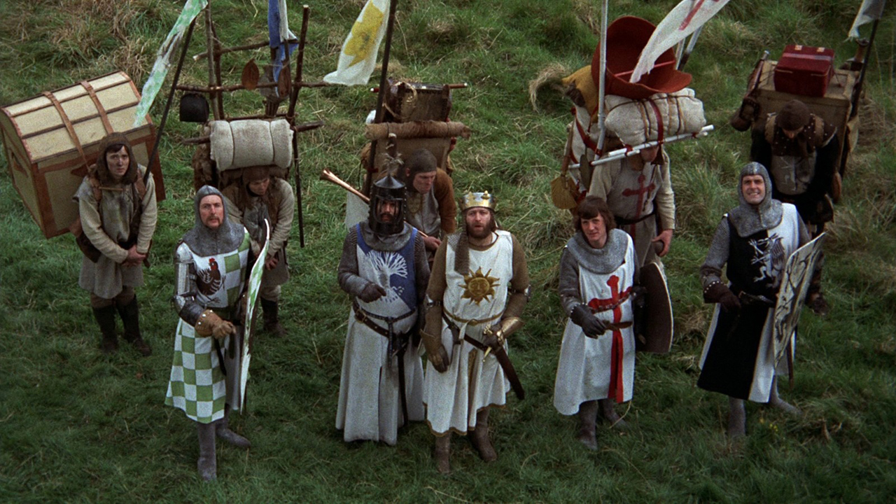 Several men in historical outfits look up in Monty Python and the Holy Grail.