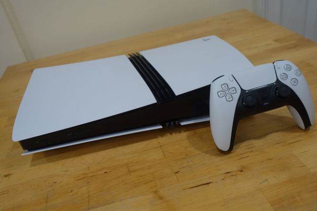 A PS5 Pro sits on a table with a DualSense.