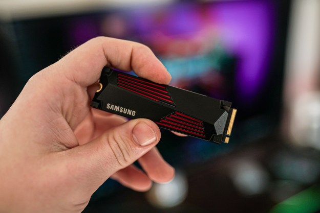 A hand holding the Samsung 990 Pro SSD.