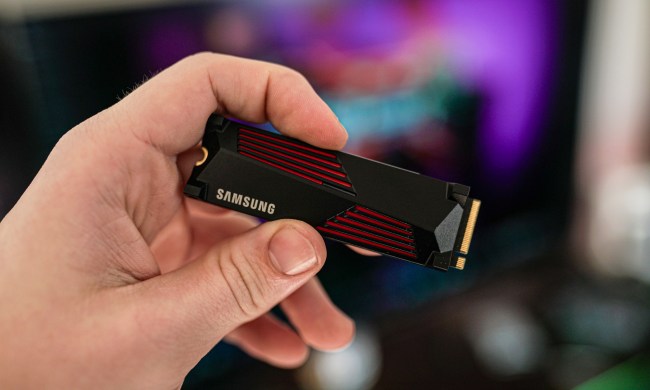 A hand holding the Samsung 990 Pro SSD.