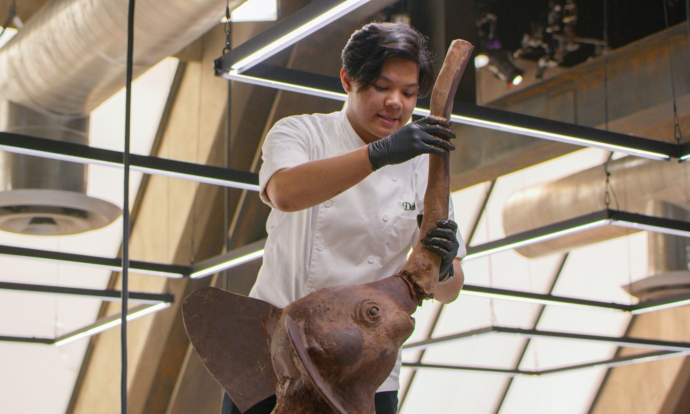 A competitor building an elephant out of chocolate in School of Chocolate