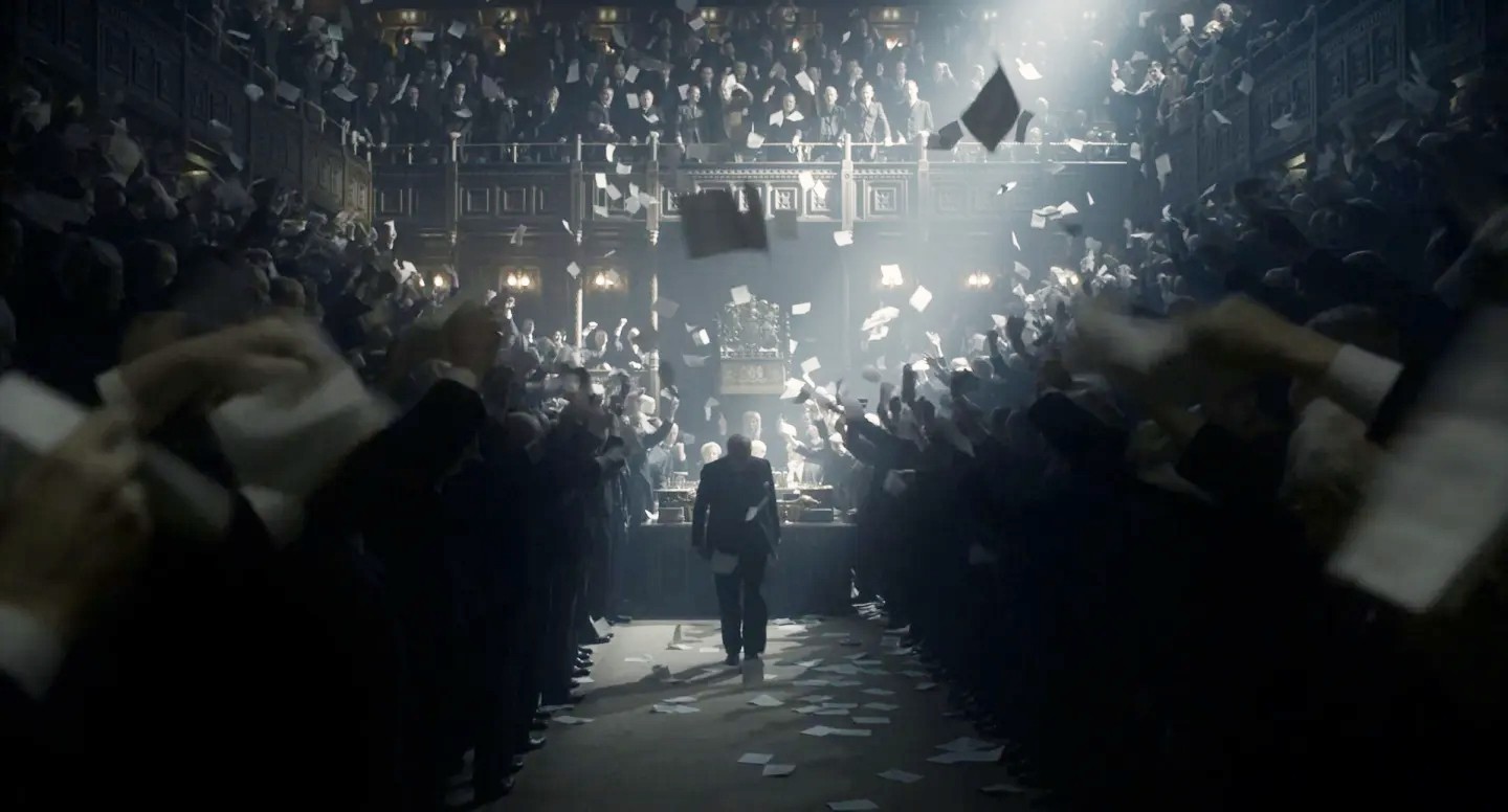 A man walks in a crowded hall in Darkest Hour.