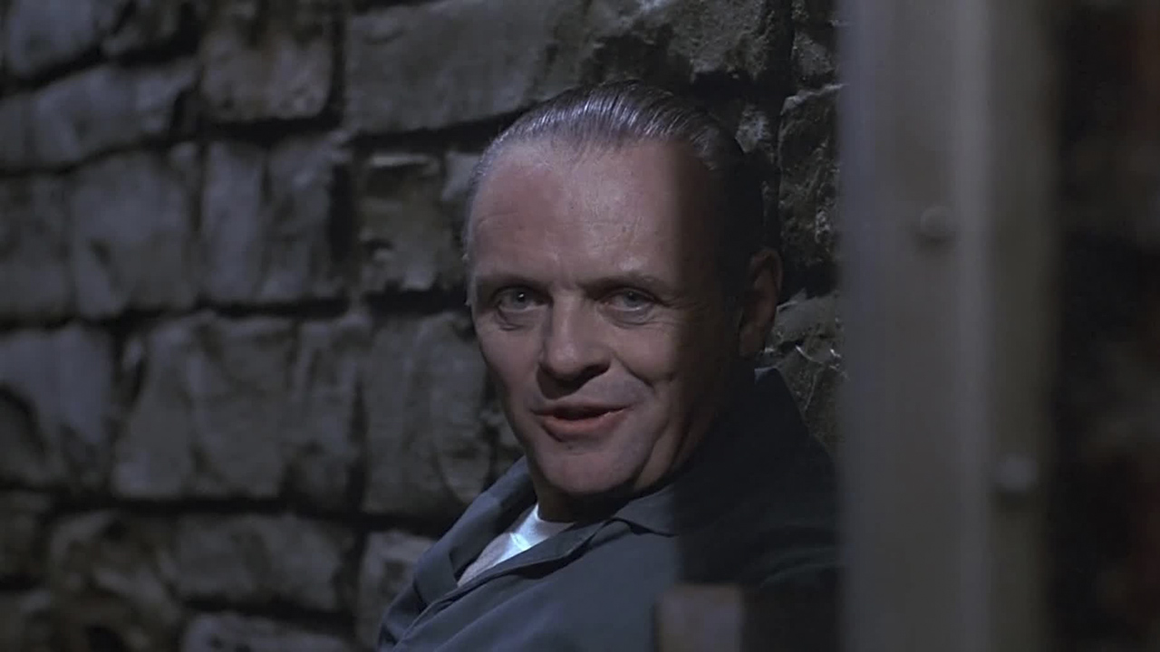 Anthony Hopkins como Hannibal Lecter sonriendo desde su celda en El silencio de los corderos.