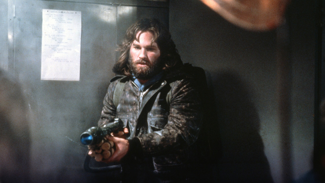 Un joven Kurt Russell empuñando un arma en la película The Thing.