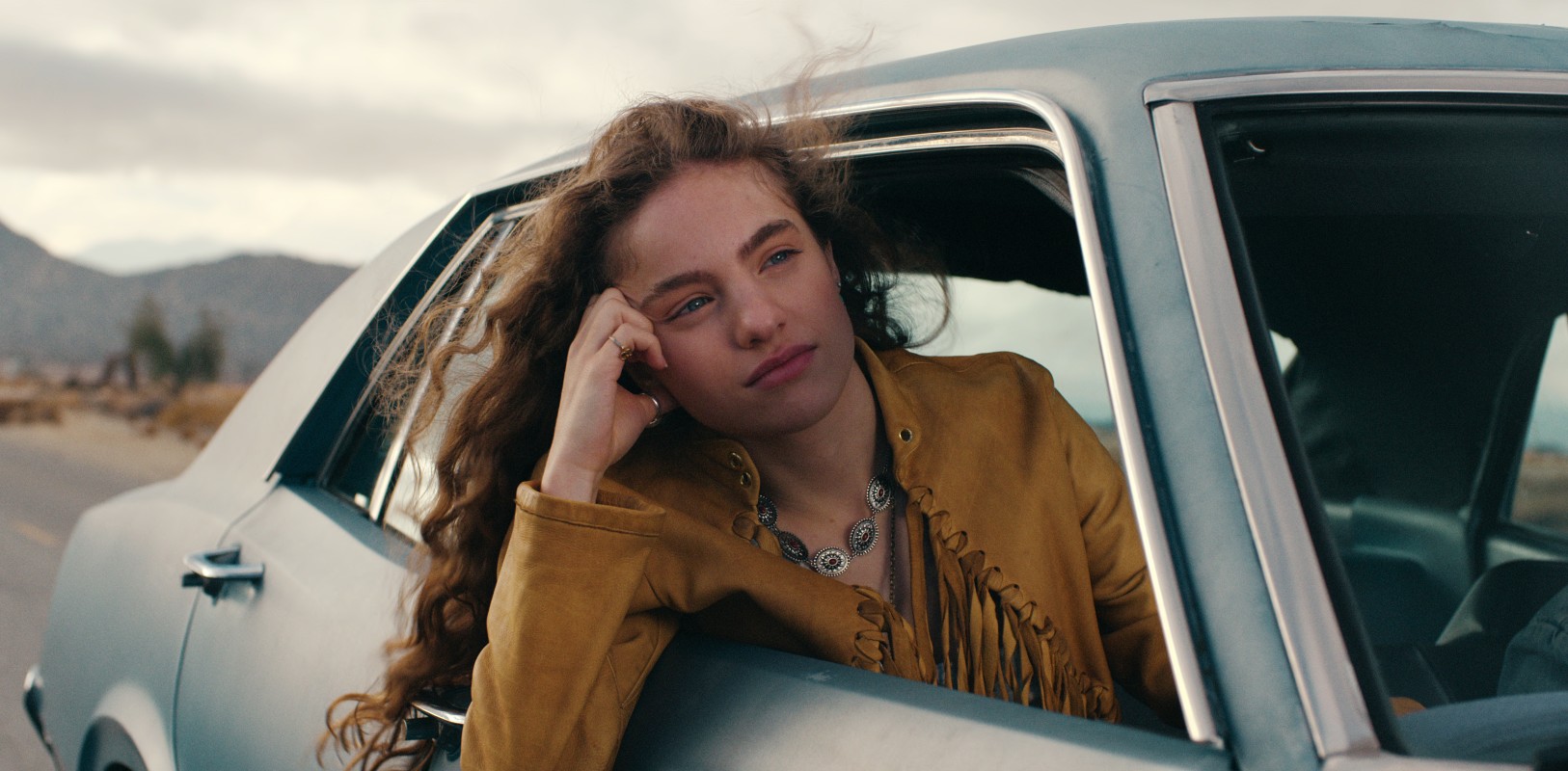 A girl leans out of a car window in Woman of the Hour.