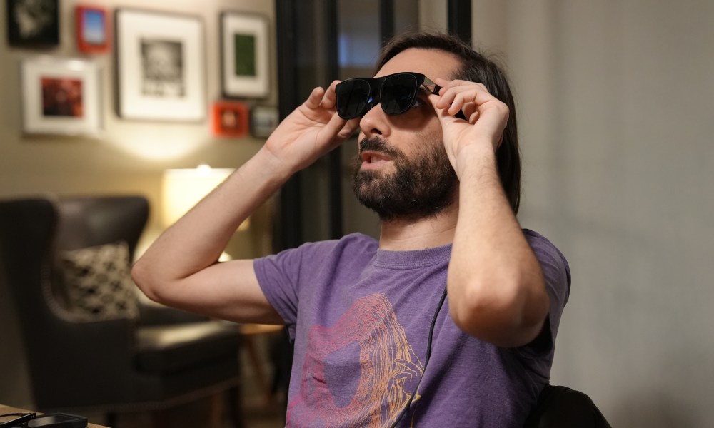 A man wears a pair of Xreal One glasses.