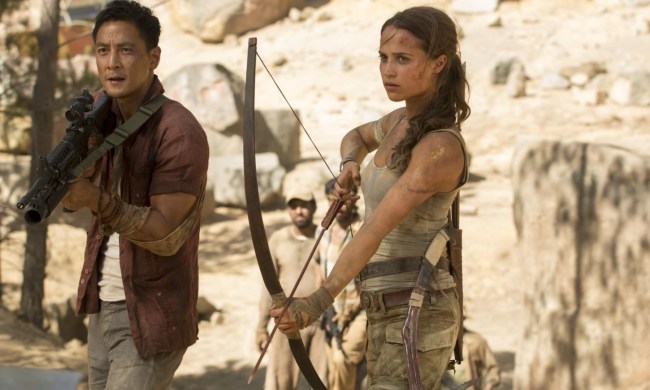 A woman holds a bow and arrow next to a man holding a gun.