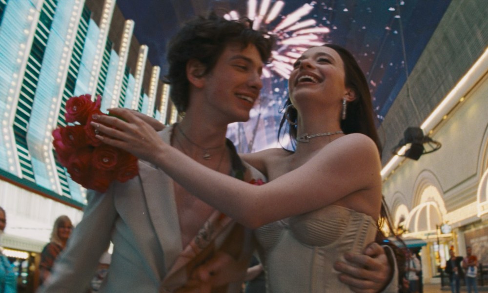 Mark Eydelshteyn and Mikey Madison dance against a blur of Las Vegas lights in a shot from the movie Anora.